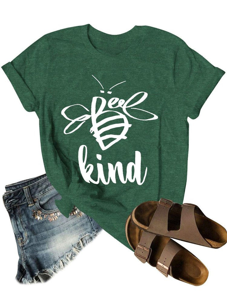 Green t-shirt with 'Be kind' bee design, denim shorts, and brown sandals on a white background