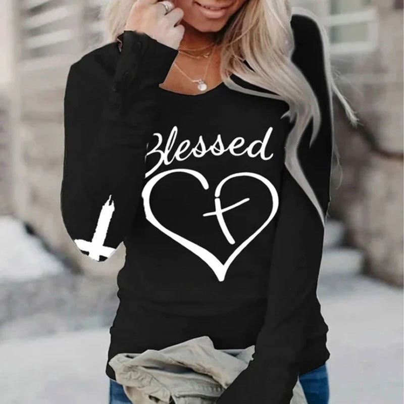 Black sweatshirt with 'Blessed' and heart design worn by a person outdoors.