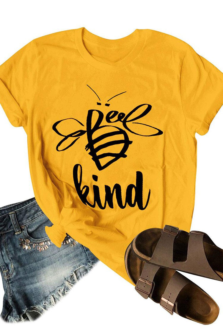 Yellow t-shirt with 'Be kind' design, denim shorts, and sandals on a white background